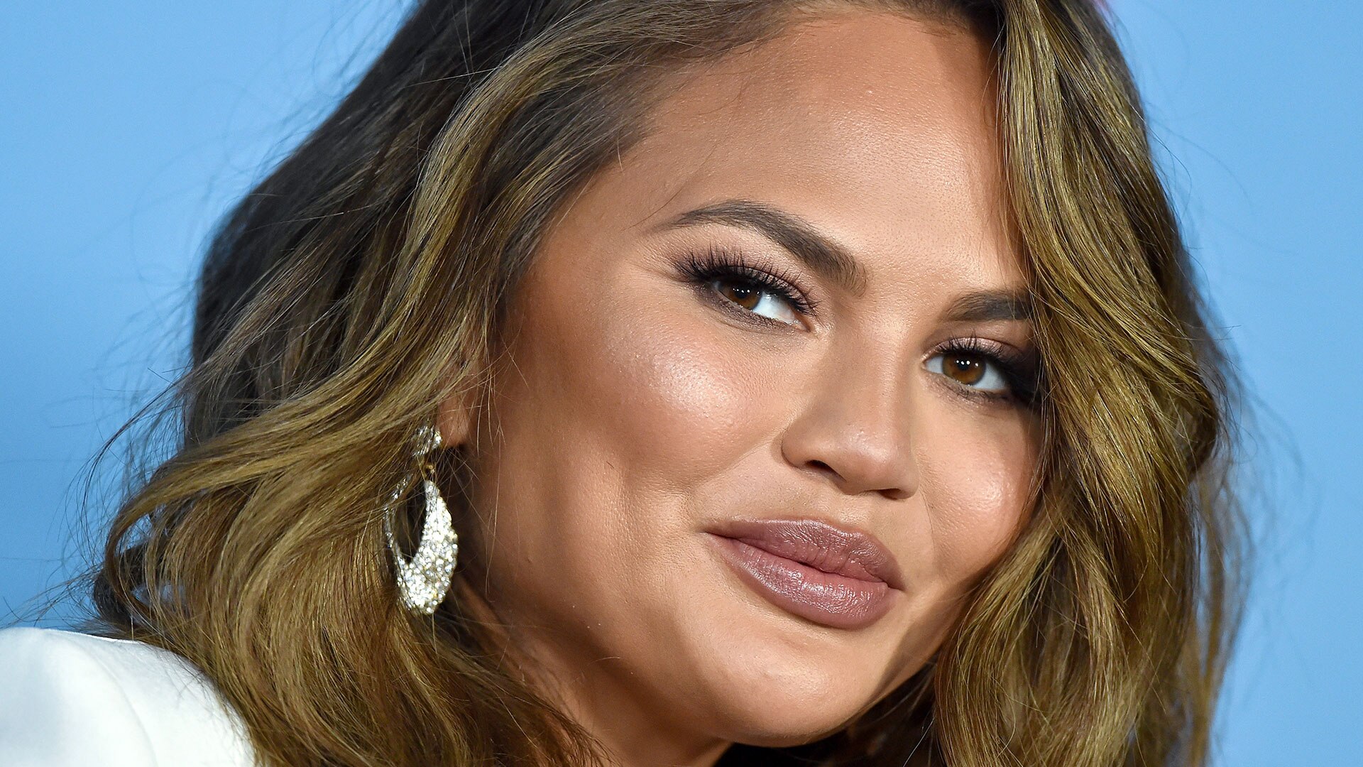 Chrissy Teigen shares topless snap before flying to Clive 